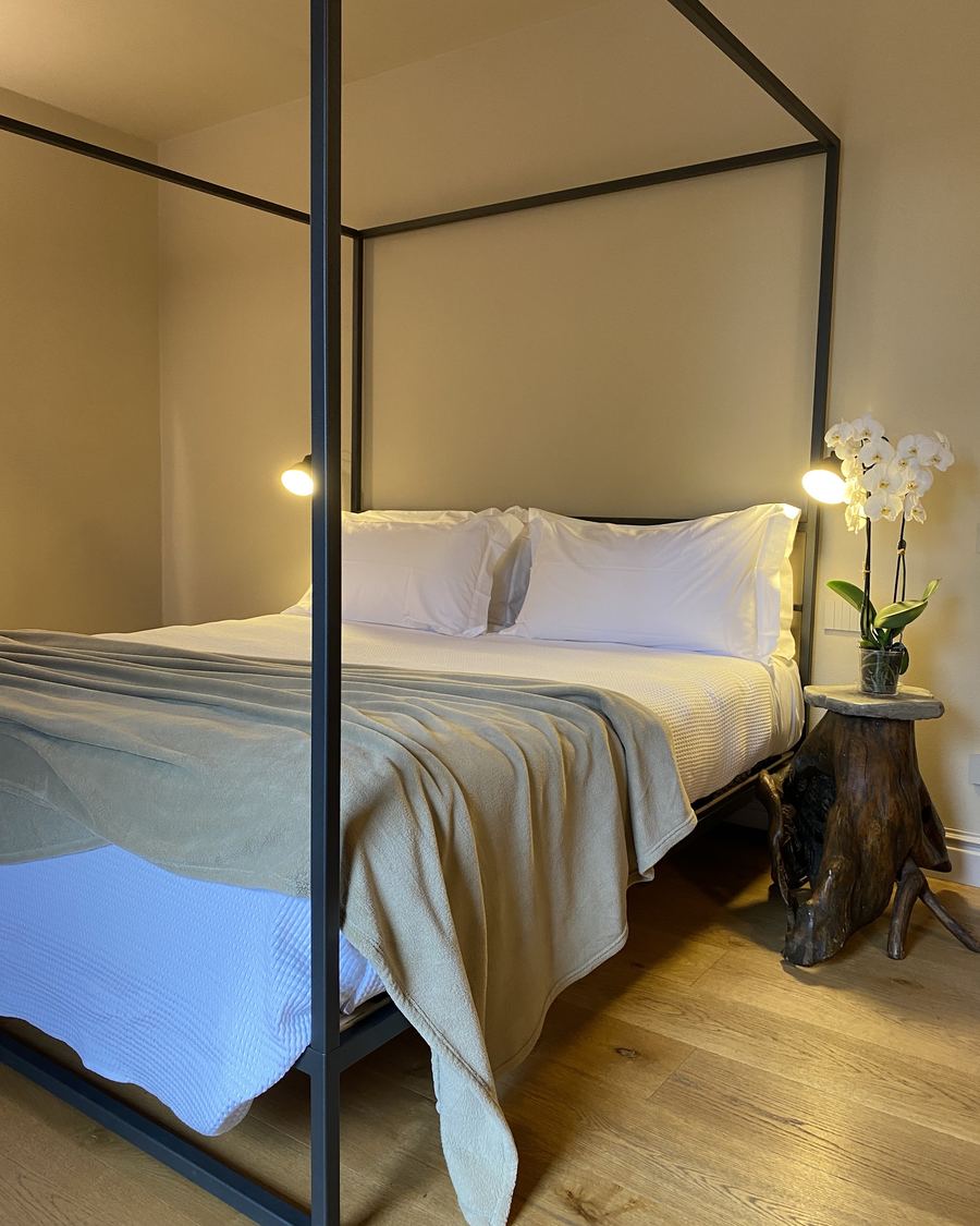 Una delle camere della tenuta, con il letto a baldacchino e le luci calde