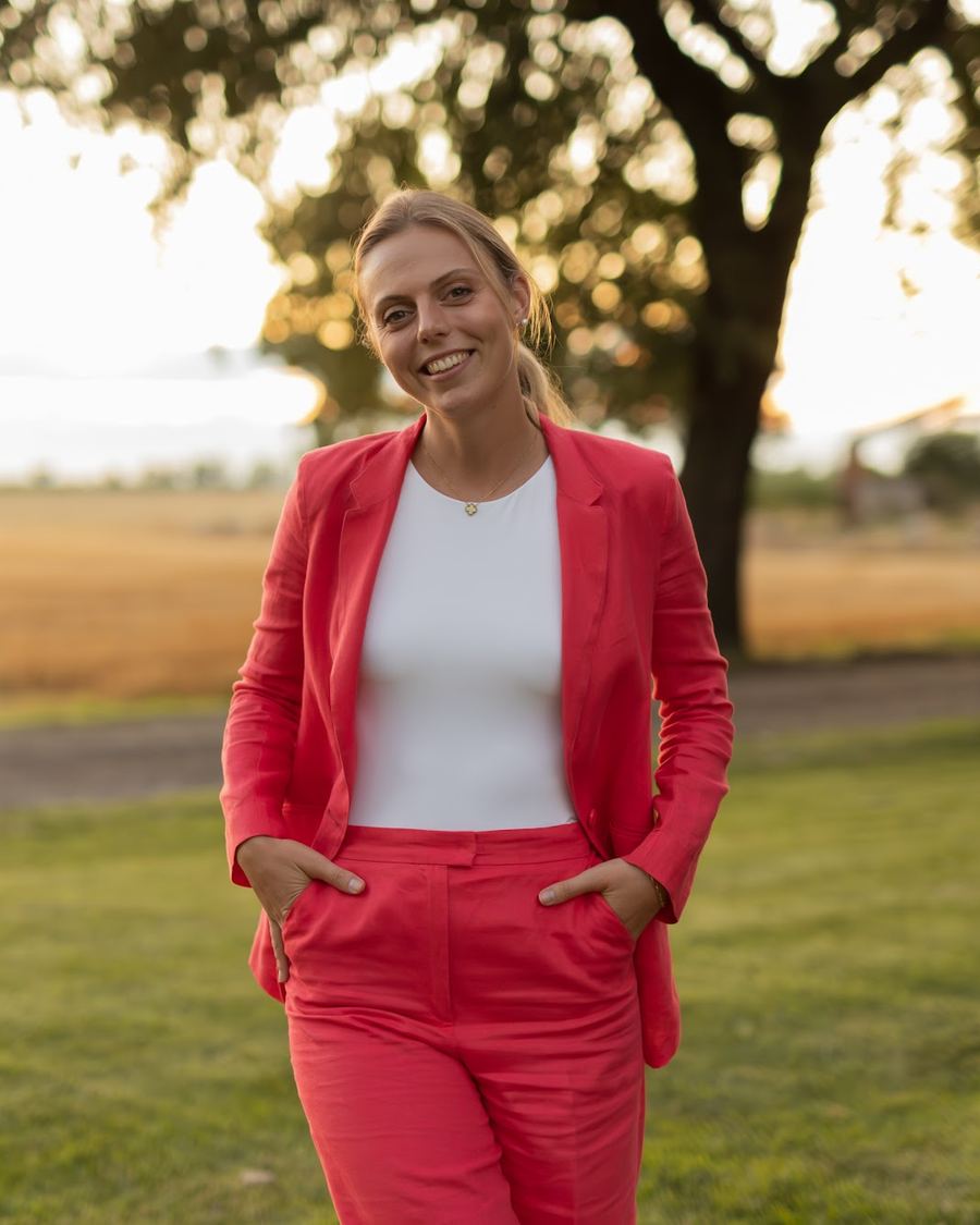 Caterina, sorridente, sul prato della tenuta al tramonto